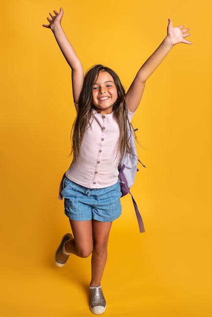 Smiling Schoolgirl with Arms Raised